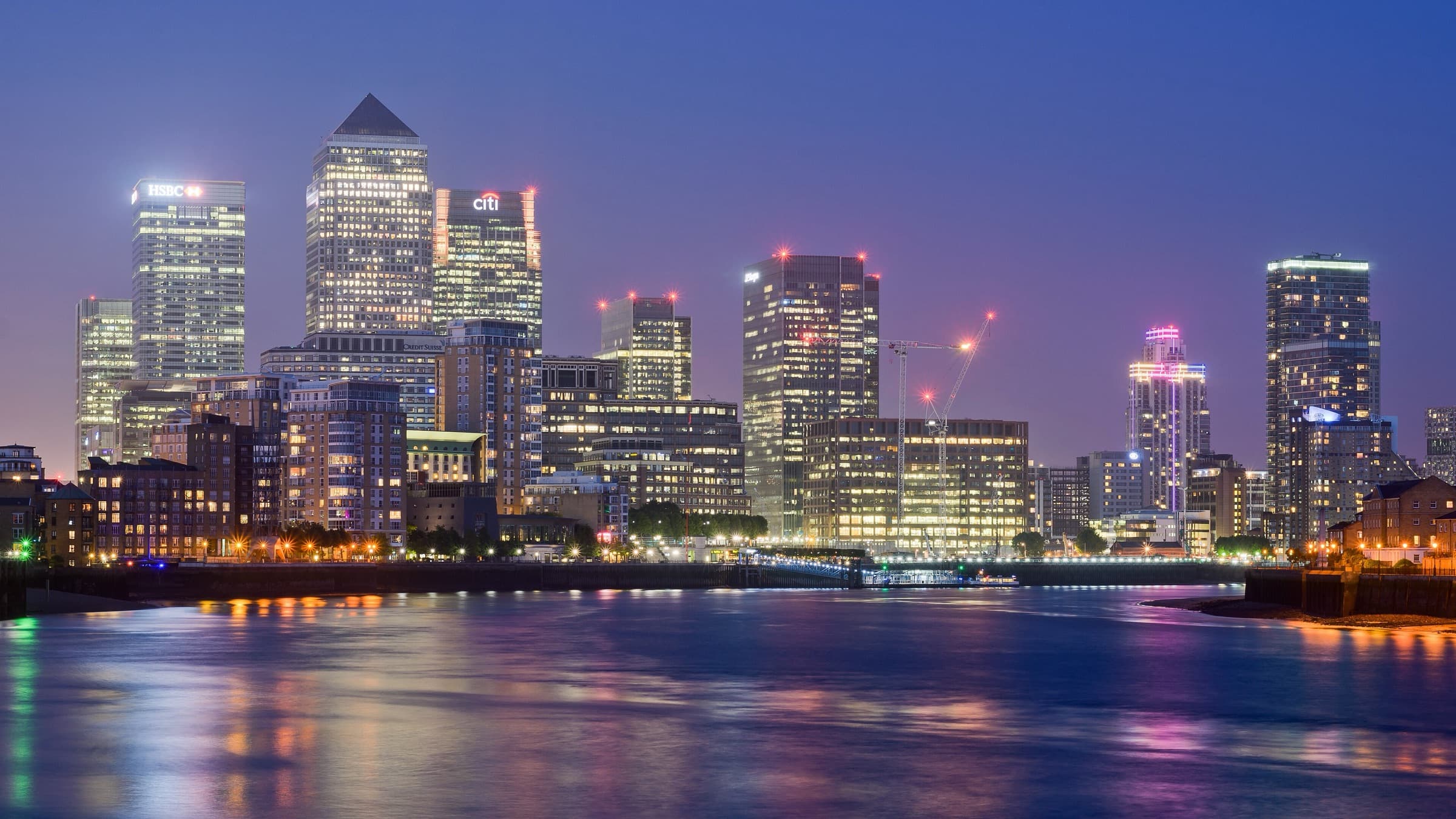 Canary Wharf’s financial district lit up across the water at twilight